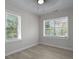 Well-lit bedroom featuring two windows, light gray walls and modern wood-look floors at 2460 Surprise St, North Charleston, SC 29405