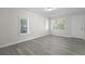 Bright living room featuring new gray flooring and three windows at 2460 Surprise St, North Charleston, SC 29405