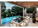 Serene outdoor patio with a pool, dining area, and beautiful wooded views at 304 Carolina Blvd, Isle of Palms, SC 29451