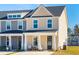 Charming two-story new townhome with covered porch and front yard on a clear day at 314 Green Fern Dr, Summerville, SC 29483