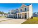 Charming new townhomes with driveways and landscaped front yards on a clear, sunny day at 314 Green Fern Dr, Summerville, SC 29483