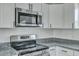 Updated kitchen features white cabinets, stainless steel appliances, and gray granite countertops at 3564 Blanding Dr, Johns Island, SC 29455