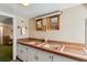 Bathroom featuring double sinks, tiled countertop, and mirrors over cabinets at 4 St Teresa Dr, Charleston, SC 29407