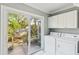 Bright laundry room with washer/dryer and sliding glass door to the outside patio at 4 St Teresa Dr, Charleston, SC 29407
