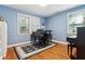 Light blue living room with hardwood floors featuring two pianos and natural lighting at 4 St Teresa Dr, Charleston, SC 29407