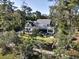 Aerial view of a stately home nestled amidst lush trees with a well-manicured lawn and fenced in back yard at 4086 Lady Banks Ln, Ravenel, SC 29470