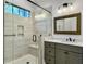 Modern bathroom features a glass-enclosed shower with bench and a gray vanity with white countertop at 4086 Lady Banks Ln, Ravenel, SC 29470