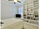 Bright bedroom featuring carpet floors, ceiling fan, and a wall of built-in shelving at 4086 Lady Banks Ln, Ravenel, SC 29470