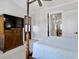 Comfortable bedroom with a four-poster bed, a TV, and a doorway to the living space at 4086 Lady Banks Ln, Ravenel, SC 29470