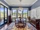 Elegant dining room with a chandelier, large windows, wainscoting and stylish furnishings at 4086 Lady Banks Ln, Ravenel, SC 29470