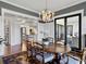 Open-concept dining area with coffered ceilings, modern chandelier, and large sliding glass doors at 4086 Lady Banks Ln, Ravenel, SC 29470