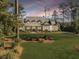 Stunning exterior showcasing a beautifully landscaped front yard and charming two-story home at sunset at 4086 Lady Banks Ln, Ravenel, SC 29470