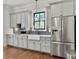 Well-lit kitchen with white cabinets, a stainless steel refrigerator, and stylish backsplash at 4086 Lady Banks Ln, Ravenel, SC 29470