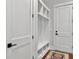 Organized mudroom area featuring built-in shelving and a bench with two doors and a rug at 4086 Lady Banks Ln, Ravenel, SC 29470