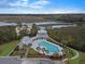 Stunning aerial view of a community pool with ample seating surrounded by lush landscaping and serene marsh views at 4086 Lady Banks Ln, Ravenel, SC 29470