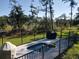 An inviting pool in a fenced yard with a view of surrounding marsh and trees at 4086 Lady Banks Ln, Ravenel, SC 29470
