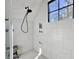 Bright shower with white tile, black fixtures, seating, and shampoo storage at 4086 Lady Banks Ln, Ravenel, SC 29470