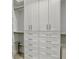 Spacious walk-in closet with white cabinets, drawers and plenty of hanging storage space at 4086 Lady Banks Ln, Ravenel, SC 29470