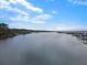 Scenic view of a tranquil river, waterfront dock, and lush green landscape under a bright, cloudy sky at 4086 Lady Banks Ln, Ravenel, SC 29470