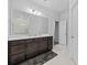 Bright bathroom featuring a large mirror, dark cabinets, and a shower with white tiling at 460 Cool Bend Ln, Summerville, SC 29486