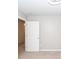 An empty bedroom with neutral-colored walls, carpeted floors, and a closed white door at 4809 Bushel Rd, Ladson, SC 29456