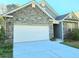 Home exterior features a two-car garage, beautiful stonework and low maintenance landscaping at 482 Oak View Way, Summerville, SC 29483