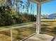 A screened porch overlooks a large backyard with green grass, trees, and neighboring homes in the distance at 482 Oak View Way, Summerville, SC 29483