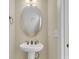 Elegant powder room features a pedestal sink, oval mirror, and classic fixtures, showcasing a clean design at 4913 Lake Palmetto Ln, North Charleston, SC 29418