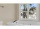 Bathroom with a tub and a large window looking out to palm trees at 4913 Lake Palmetto Ln, North Charleston, SC 29418