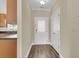 Inviting entryway with hardwood floors, a modern white door, and a glimpse of the kitchen with updated appliances at 4913 Lake Palmetto Ln, North Charleston, SC 29418