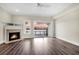 Bright living room featuring a fireplace, ceiling fan, wood floors, and balcony access with a beautiful sunset view at 4913 Lake Palmetto Ln, North Charleston, SC 29418