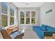 Cozy sitting room features natural light through large windows and a comfortable chair with a blue futon at 500 Bucksley Ln # 308, Charleston, SC 29492