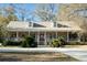 Charming brick home featuring a welcoming front porch with white railing, dormer windows, and well-maintained landscaping at 5367 Boone Run, Hollywood, SC 29449