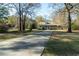 Inviting home with a long driveway, lush green lawn and mature trees creating a serene setting at 5367 Boone Run, Hollywood, SC 29449