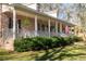 Inviting front porch of a brick home with a railing, ferns and an American flag on display at 5367 Boone Run, Hollywood, SC 29449