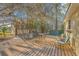 Back deck featuring a grill, chairs, an outdoor dining table, and views of the surrounding trees at 5758 Chisolm Rd, Johns Island, SC 29455