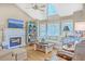Bright living room featuring a vaulted ceiling, fireplace, large windows, and comfortable seating at 5758 Chisolm Rd, Johns Island, SC 29455