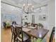 Bright dining room with stylish chandelier, wainscoting, and view into the living area at 614 Cummings Chapel Rd, Ridgeville, SC 29472