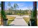 View of the driveway and palm tree island from covered outdoor space at 614 Cummings Chapel Rd, Ridgeville, SC 29472