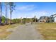 Gated driveway leading to a stunning white farmhouse with detached garages at 614 Cummings Chapel Rd, Ridgeville, SC 29472