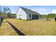 Side view of a modern farmhouse-style home with white siding and a well-manicured lawn at 614 Cummings Chapel Rd, Ridgeville, SC 29472