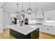 A bright kitchen features white cabinets, stainless steel appliances, and a large center island with pendant lighting at 614 Cummings Chapel Rd, Ridgeville, SC 29472