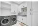 Well-lit laundry room featuring modern washer and dryer and white custom cabinetry at 614 Cummings Chapel Rd, Ridgeville, SC 29472