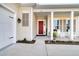 A cozy front porch featuring a red door, white columns, and rocking chairs, creating a welcoming entrance at 663 Marsh Cove Cir, Summerville, SC 29486