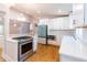 Modern kitchen with sleek white cabinets, stainless steel appliances, stone countertops and hardwood flooring at 708 S Laurel St, Summerville, SC 29483