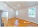 Bright living area with vaulted ceiling features gleaming hardwood floors and lots of natural light from large windows at 708 S Laurel St, Summerville, SC 29483