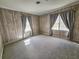 Bedroom featuring two windows with gray curtains, wood paneling, carpet, and a ceiling vent at 8524 Cane Branch Rd, Ruffin, SC 29475