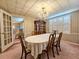 Dining room view showcases elegant chandelier, shuttered windows, and table set for a formal meal at 8524 Cane Branch Rd, Ruffin, SC 29475