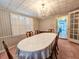 Bright dining space with plantation shutters, ornate chandelier and a peek into other rooms at 8524 Cane Branch Rd, Ruffin, SC 29475