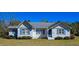 Quaint home with blue shutters and a gray roof, complemented by green landscaping at 8524 Cane Branch Rd, Ruffin, SC 29475